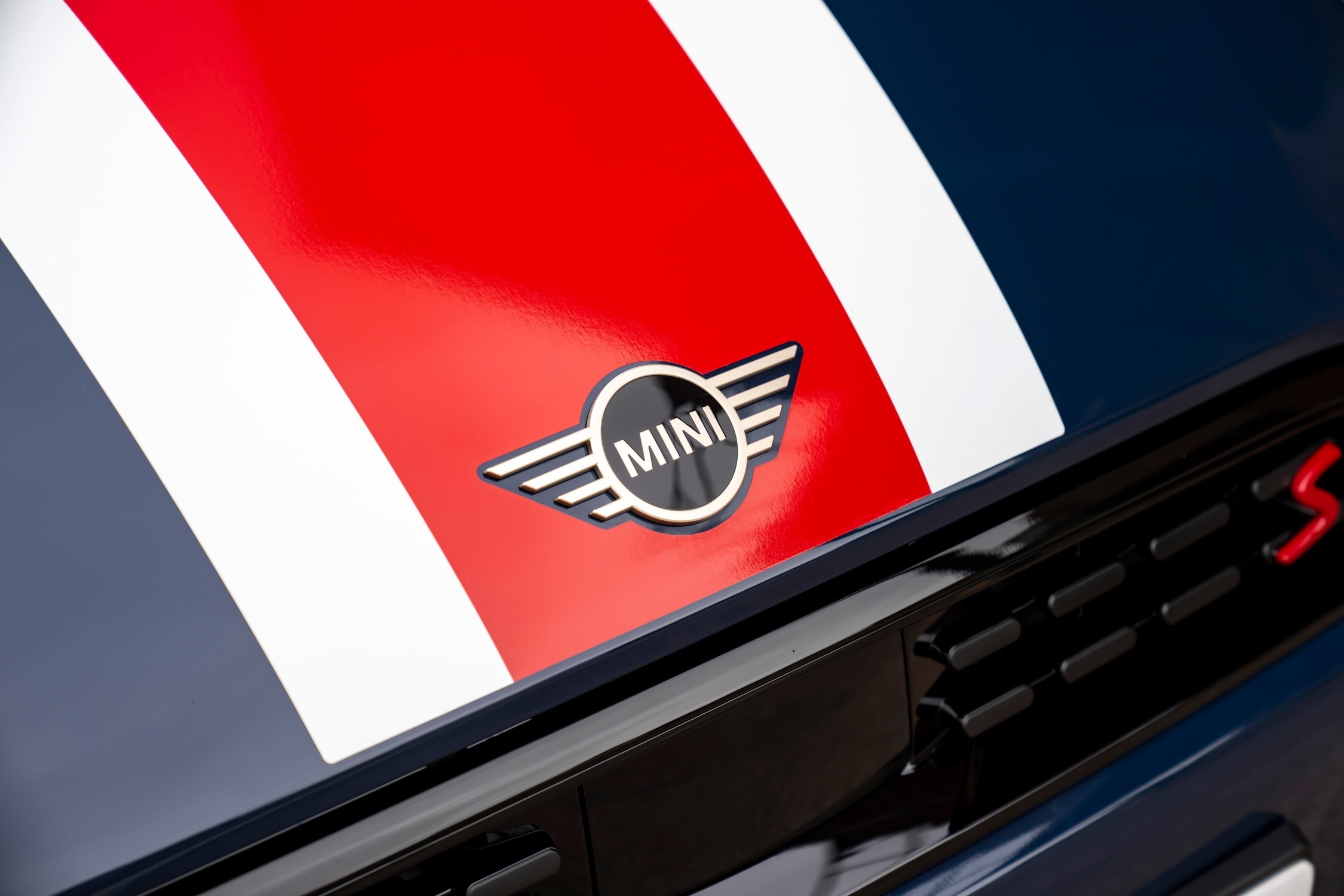 Detalhe do capô do MINI Cooper Oxford Edition, com faixas vermelha e branca e logótipo MINI em destaque